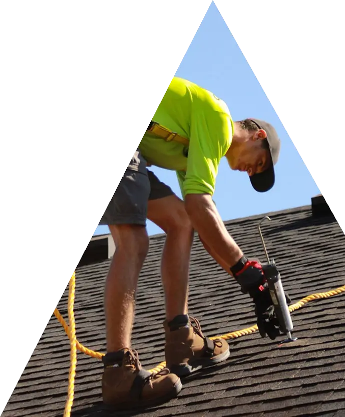 Roofer fixing shingles on a pitched roof